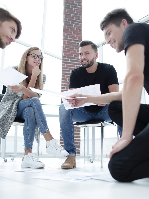 Business people sitting in office working with document having discussion.